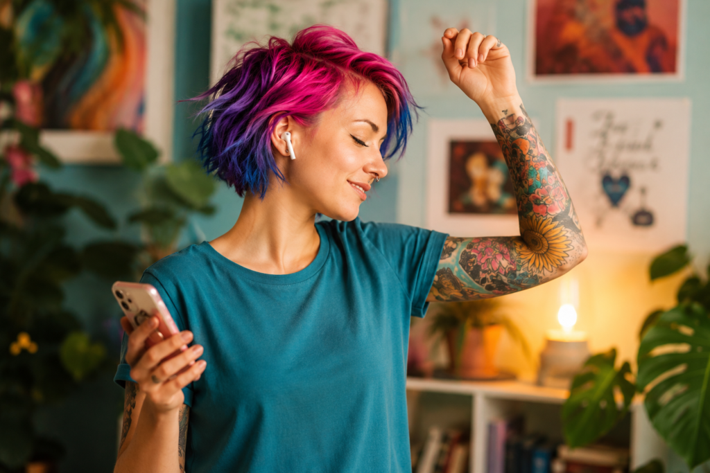 Woman with colourful hair dancing to music while wearing wireless earbuds, demonstrating movement as a tool for stress relief and emotional well-being.